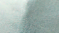 Close-up of light blue fabric with a darker vertical crease.