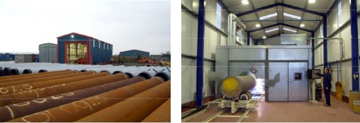 Industrial facility showing orange pipes in an outdoor yard and a spacious indoor workshop with machinery and a yellow spherical vessel.