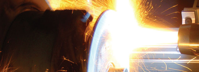 Close-up of a metal grinding wheel in operation with bright sparks flying.