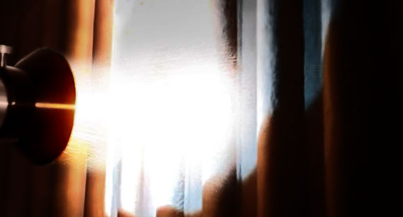 Bright light streaming through a narrow gap between a partially opened door, with a door knob visible on the left.