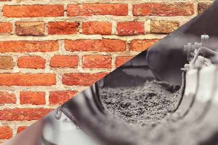 Close-up of a shiny curved metal surface in front of a red brick wall.