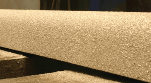 Close-up of overlapping beige foam boards with rough, textured surfaces.