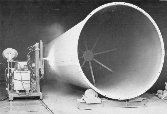 A large conical rocket nozzle on a test stand with testing equipment nearby.