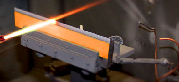 A glowing orange-hot metal bar held in a bench vise at a workshop.