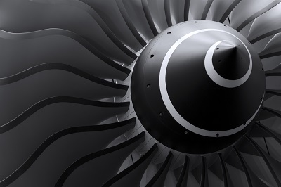 Close-up of a jet engine turbine with curved blades radiating from a central hub.