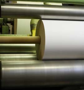 Close-up of metal rollers with a white sheet passing between them.