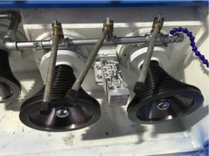 Two black pulley wheels with belts mounted on a metal frame.