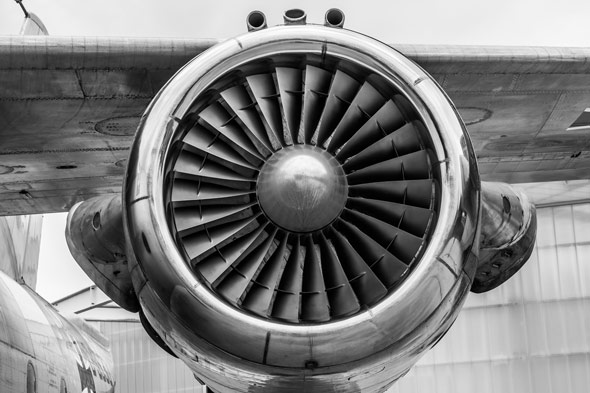 Front view of a jet engine nacelle with visible fan blades, mounted on an aircraft.