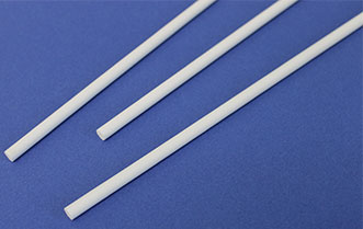 Three white plastic rods lie diagonally on a blue background.