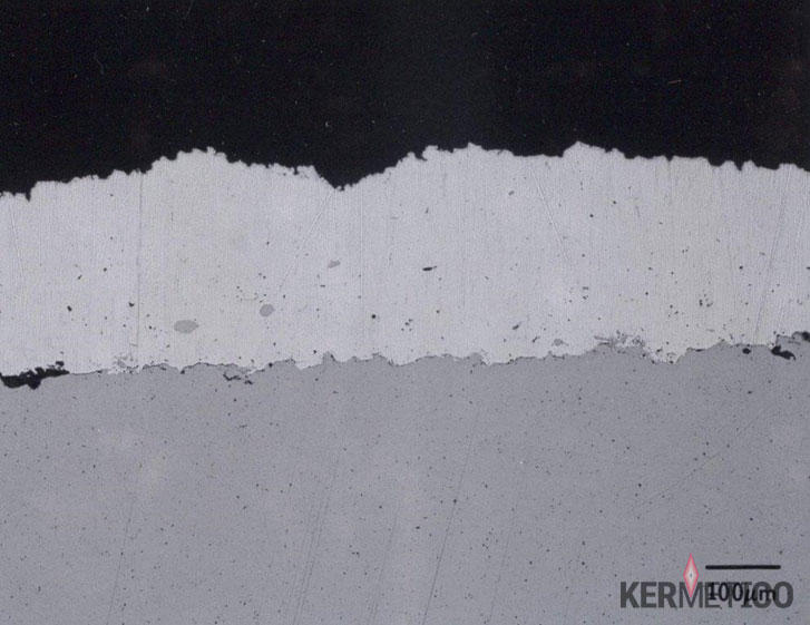 Close-up of a torn white band separating a black upper surface from a gray lower surface.