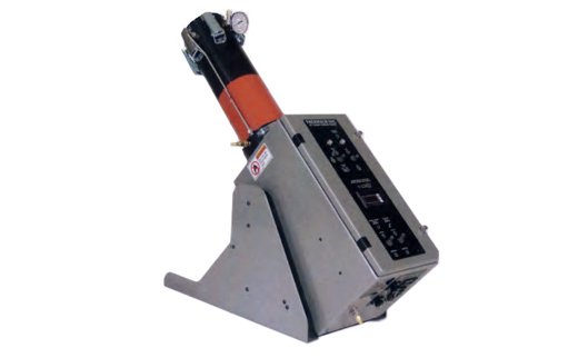Metallic laboratory instrument on an angled stand with an orange cylindrical module on top and a black control panel.