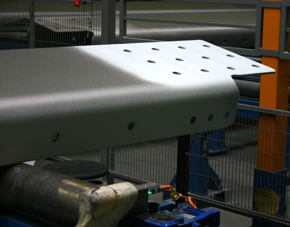 Industrial metal machine component with a perforated top plate in a factory setting.