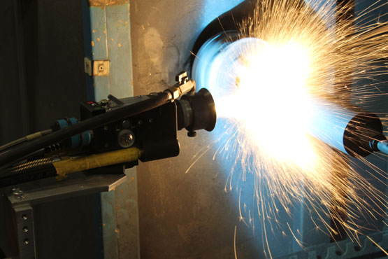 A welding arc with bright sparks flying as a welding torch fuses metal pieces.